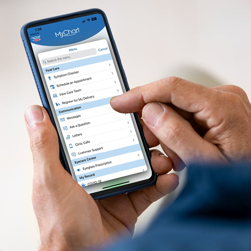 Hand scrolling through MyChart options on cellphone