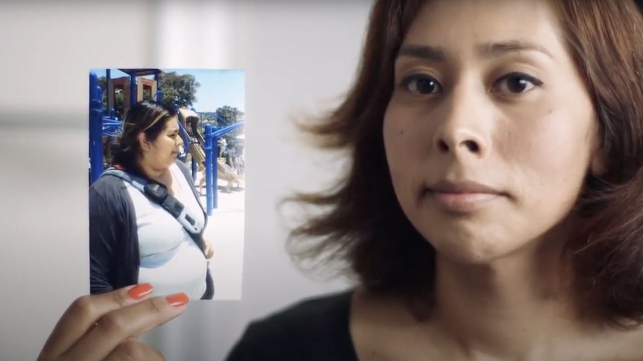 Woman holds picture of herself before she lost weight.
