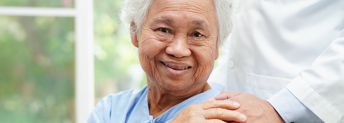 medical provider pats shoulder of older patient