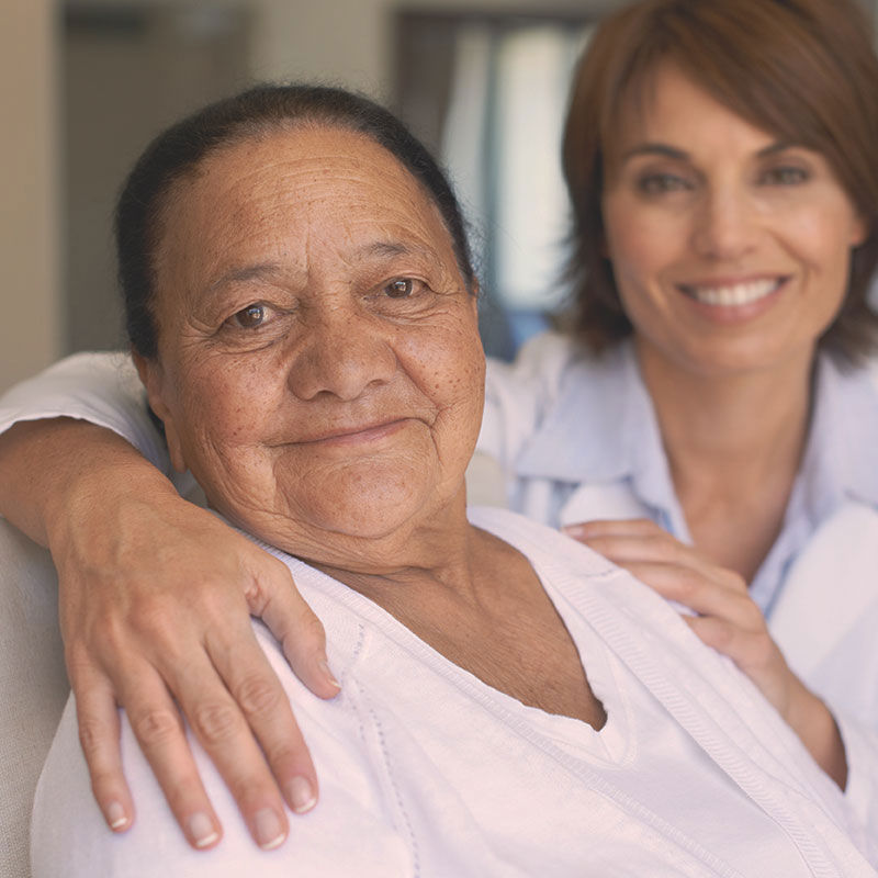 A woman with her arm around an older woman