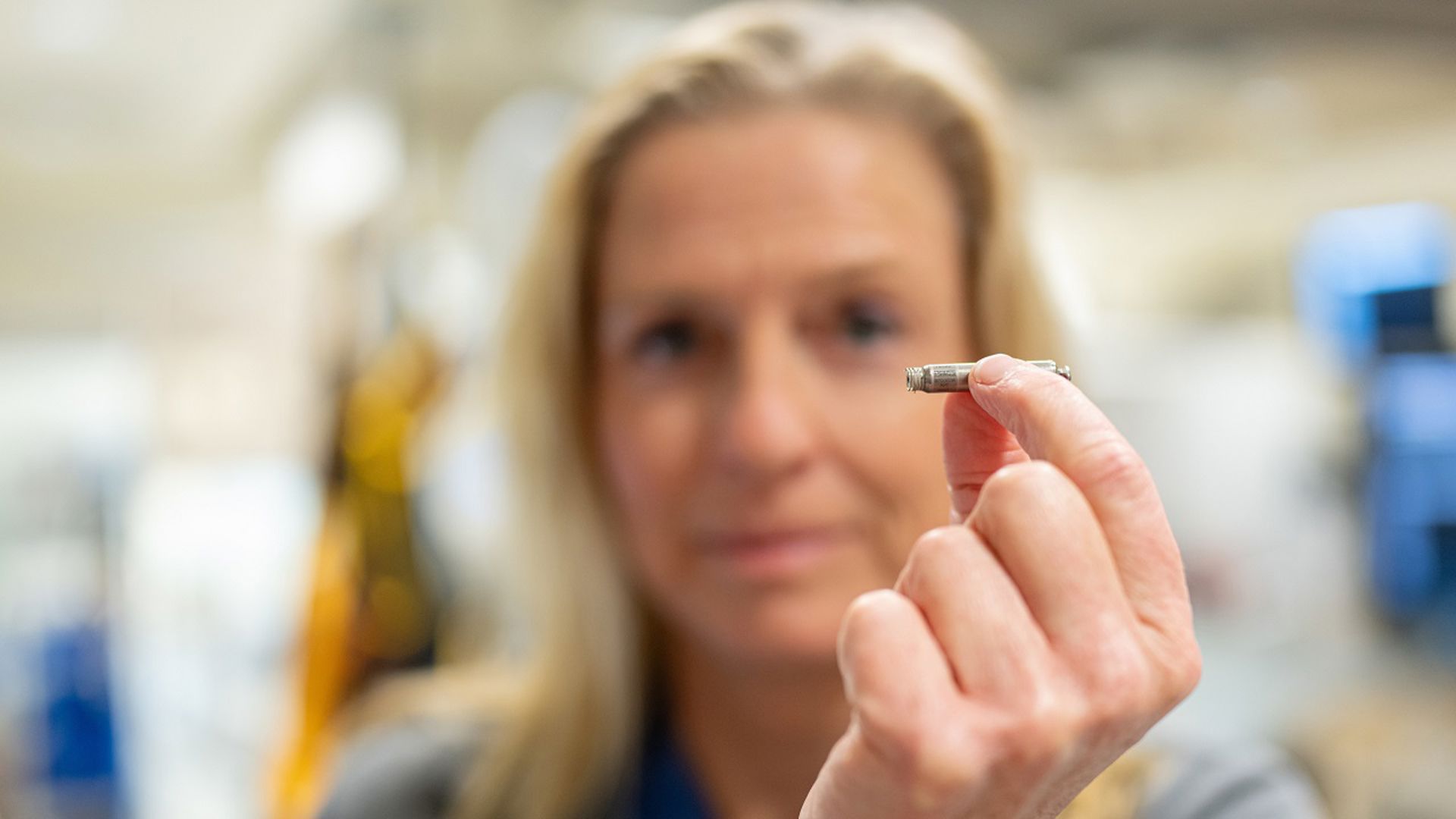 Dr. Green holds a leadless pacemaker with her fingers to show how small it is