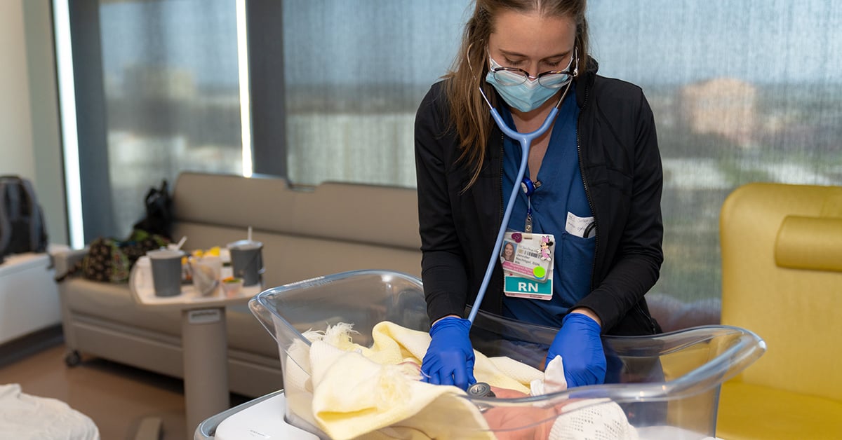 Masked nurse tends to baby in Jacobs Medical Center Birth Center