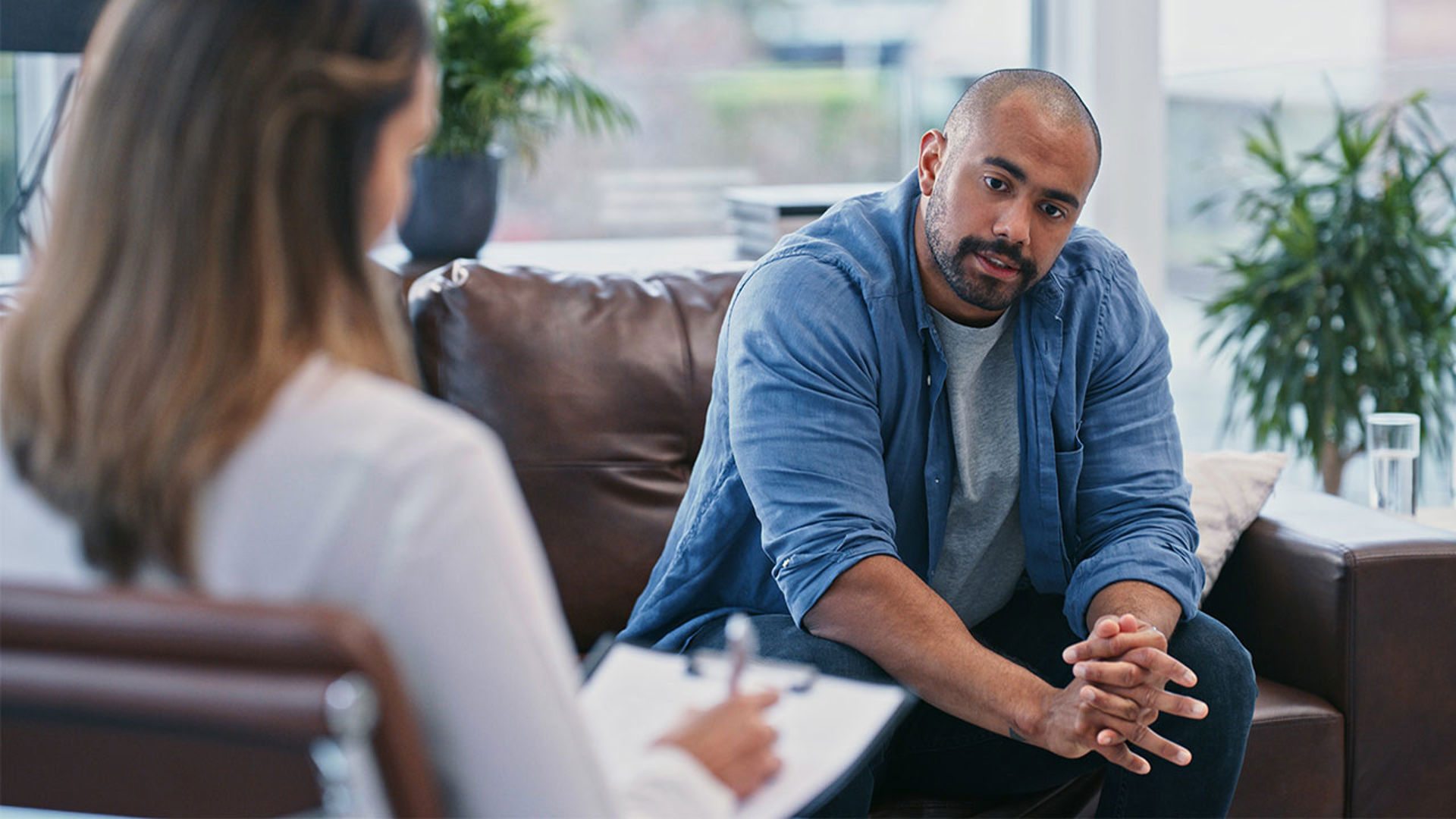 clinician with man sitting on couch