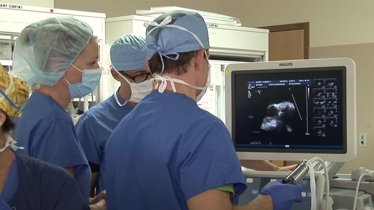 Doctors observe heart on monitor during ICD extraction procedure