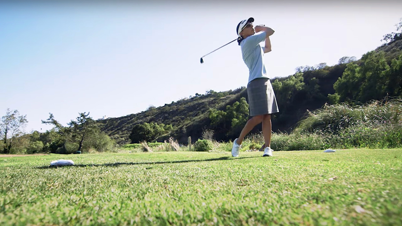 Woman golfer swinging her club