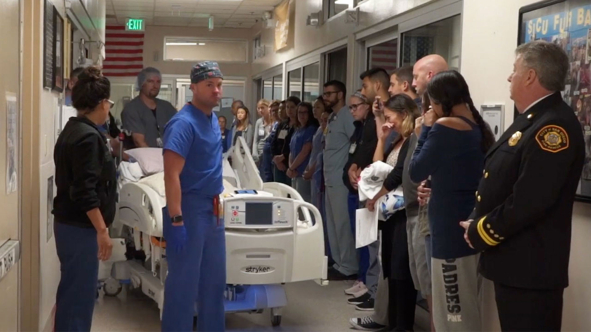 Friends and family standing by one side of the corridor cry as Fire Captain Robin Cervantes's body is wheeled to the operating room for the donation by hospital workers.